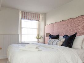 A bedroom with a bed and window at Apartment 1, 86 Dyer Street Cirencester