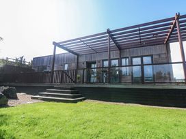 A wooden building with a deck and steps at Lodge 83, Gwel an Mor, Portreath