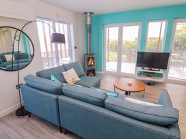 A living room with a sofa and television at Lodge 83, Gwel an Mor in Portreath