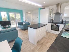 An open living space with a kitchen and seating area at Lodge 83, Gwel an Mor, Portreath