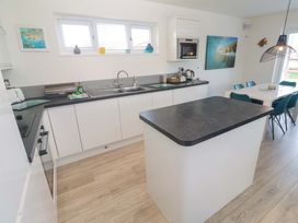 A kitchen with a sink and dining area at Lodge 83, Gwel an Mor in Portreath