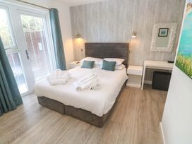 A bedroom with a bed and bedside table at Lodge 83, Gwel an Mor in Portreath