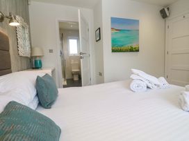 A bedroom with a bed and a bathroom visible at Lodge 83, Gwel an Mor, Portreath