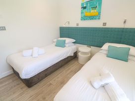 A bedroom with two beds and a nightstand at Lodge 83, Gwel an Mor in Portreath