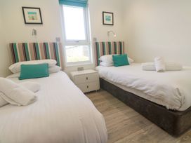 A bedroom with two single beds and a bedside table at Lodge 83, Gwel an Mor Portreath