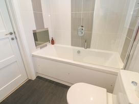 A bathroom with a bathtub and toilet at Lodge 83, Gwel an Mor in Portreath