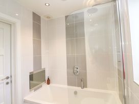 A bathroom with a bathtub and shower at Lodge 83, Gwel an Mor, Portreath