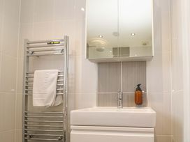 A bathroom featuring a towel rail, sink, and mirror at Lodge 83, Gwel an Mor, Portreath