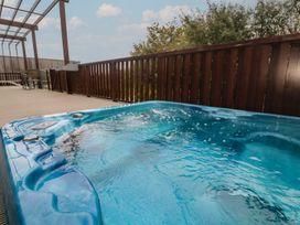 A hot tub on a deck at Lodge 83, Gwel an Mor in Portreath