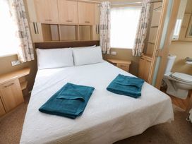 A bedroom with a bed and towels at Plot 12 in Carlisle