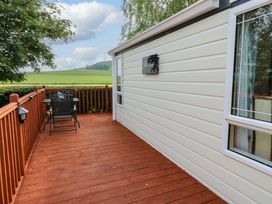 A deck area with a chair and table at Plot 12 in Carlisle