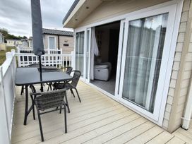 A balcony with an outdoor table and chairs at Fernwood Lodge in Fritton near Belton, Norfolk