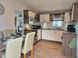 A kitchen with dining table and appliances at Fernwood Lodge in Fritton near Belton Norfolk