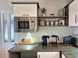 A kitchen with microwave, coffee maker, kettle and toast at Fernwood Lodge in Fritton near Belton, Norfolk