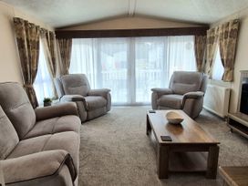 A living room with a sofa and coffee table at Fernwood Lodge in Fritton near Belton, Norfolk