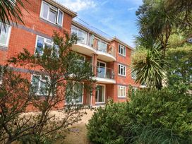 A brick building with balconies and plants at Apartment 11 in Poole