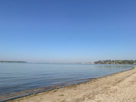 A beach with water and sand at Apartment 11 in Poole