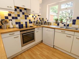 A kitchen with appliances and tiles at Apartment 11 in Poole