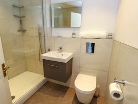 A bathroom with a shower, wash basin, and toilet at Apartment 11 in Poole