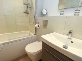 A bathroom with a bathtub, toilet, sink, and shower at Apartment 11 in Poole