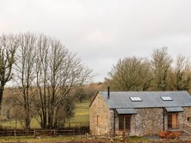 A house with trees and a fence at Lower Walreddon Farm in Tavistock