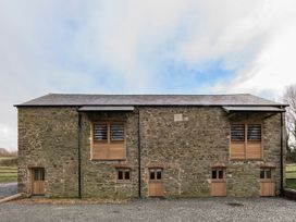 A stone building with wooden windows and doors at Lower Walreddon Farm Tavistock