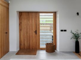 An entrance hallway with a wooden door and basket at Lower Walreddon Farm Tavistock