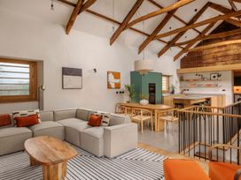 A living room with a sofa and dining area at Lower Walreddon Farm in Tavistock