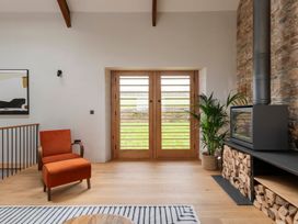 A living room with an armchair and fireplace at Lower Walreddon Farm in Tavistock