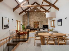 A living room with a sofa, dining table, and television at Lower Walreddon Farm in Tavistock