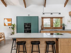 A kitchen with a central island and modern appliances at Lower Walreddon Farm in Tavistock