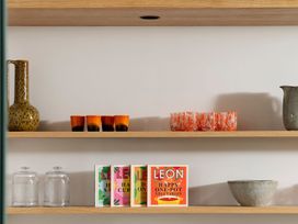 Shelves with a vase, glasses, cookbooks and a bowl at Lower Walreddon Farm Tavistock
