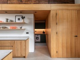 A kitchen with wooden cabinets and a washing machine at Lower Walreddon Farm in Tavistock