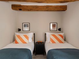 A bedroom with two beds and a nightstand at Lower Walreddon Farm Tavistock