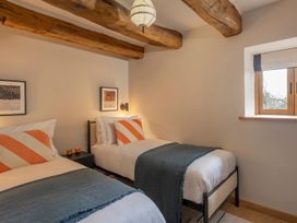 A bedroom with two beds and wall art at Lower Walreddon Farm in Tavistock