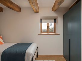 A bedroom with a bed and window at Lower Walreddon Farm Tavistock