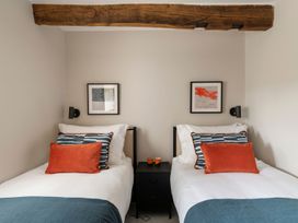 A bedroom with two beds and wall art at Lower Walreddon Farm in Tavistock