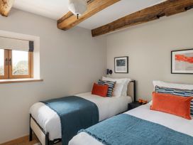 A bedroom with two beds and a window at Lower Walreddon Farm in Tavistock