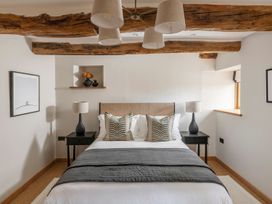 A bedroom with a bed and bedside tables at Lower Walreddon Farm in Tavistock
