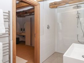 A bathroom with a shower and towel rail at Lower Walreddon Farm Tavistock