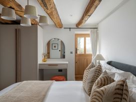 A bedroom with a bed and a mirror at Lower Walreddon Farm in Tavistock