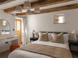 A bedroom with a bed and dresser at Lower Walreddon Farm in Tavistock