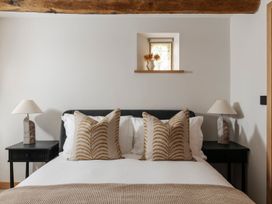A bedroom with a bed and pillows at Lower Walreddon Farm in Tavistock