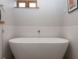 A bathroom with a bathtub and window at Lower Walreddon Farm in Tavistock