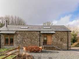A house with a deck and seating at Lower Walreddon Farm in Tavistock