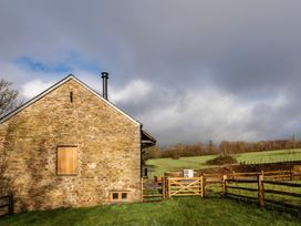 A stone building with a fence and gate at Lower Walreddon Farm Tavistock