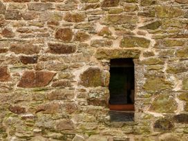A stone wall with a window opening at Lower Walreddon Farm, Tavistock