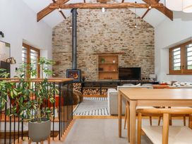 A living room with a fireplace and seating area at Lower Walreddon Barn Tavistock
