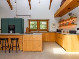 A kitchen with an island and wooden cabinets at Lower Walreddon Barn in Tavistock