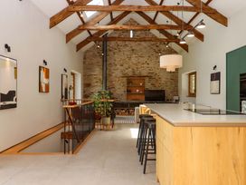 A kitchen with a large island and seating at Lower Walreddon Barn in Tavistock